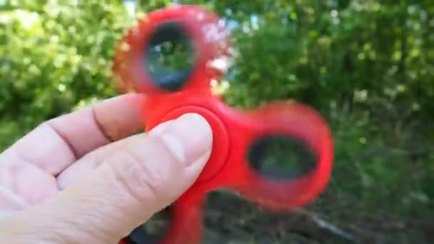 Pinwheel fidget spinner red color in the hands. — Stock Video