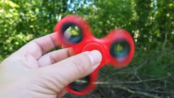 Pinwheel fidget spinner color rojo en las manos . — Vídeos de Stock