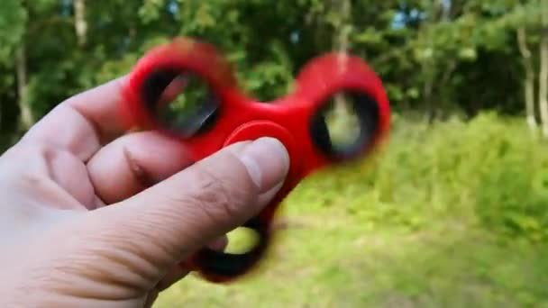 Windrad Fidget Spinner rote Farbe in den Händen. — Stockvideo