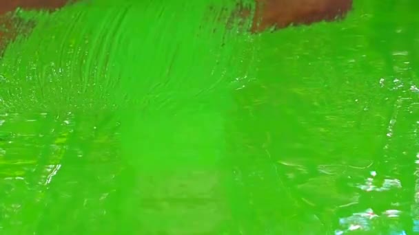 Ahşap bir yüzeyi akrilik yeşil boya ile boyama. — Stok video