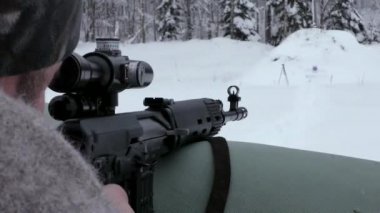 Bir keskin nişancı kışın bir Tiger karabinasını vurur. Bir hedefe ön cepheden ateş etmek..