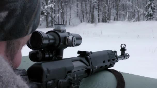 一个狙击手在冬天向虎式卡宾枪射击 通过步枪前瞄准镜向目标射击 — 图库视频影像