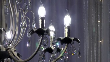 Sarayda asılı lüks kristal avize. Ampulleri ve bir sürü kolyesi olan klasik lambalar..