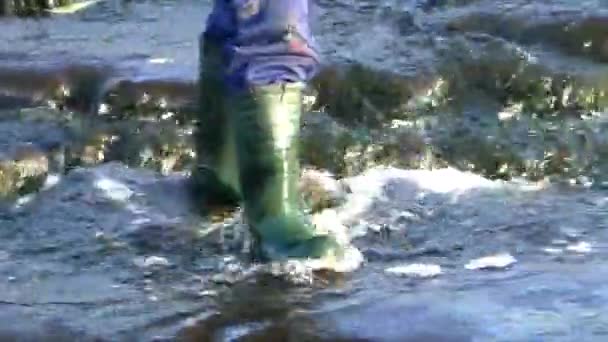Pies de un pescador con botas caminando sobre el agua. — Vídeos de Stock