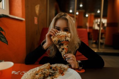 Pizza ile genç güzel kadın yüzünü kapsar. Yaşam tarzı fotoğraf.