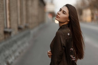 Şık moda yeşil bahar ceketli yolun yakınında sokakta poz güzel bir genç kadın portresi