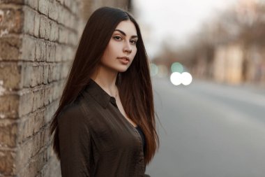 Güzel moda giysileri yakınındaki duvara yolun yakınında sokakta genç bir kadın portresi