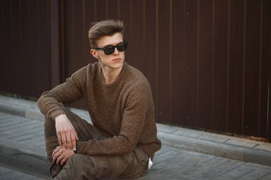 yakışıklı model adam hipster askeri moda giysileri sokakta oturan gözlüklü