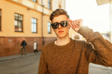 Gün batımında gözlüklü şık genç yakışıklı hipster adam