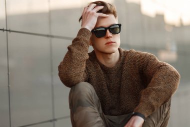 Yakışıklı hipster adam güneşli bir saç modeli ile güneş gözlüğü