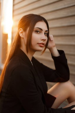 Gün batımında moda siyah paltolu güzel şık kadın modeli