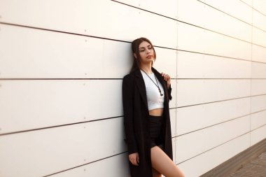 Güzel seksi model kadın şort beyaz duvara yakın poz ile siyah ceket