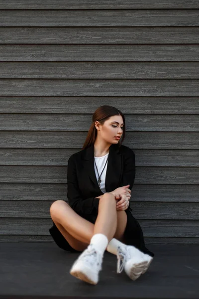 Beautiful Young Model Woman Fashion Black Coat White Sneakers Sits — Stock Photo, Image