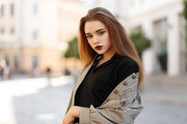 Makyaj siyah polo gömlek ve güneşli bir günde dışarıda poz moda ceket ile şık genç ve güzel kadın