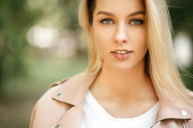 Taze güneşli bir parkta güzel bir genç sarışın kadın portresi