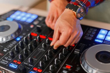 Genç Dj adam bir ses denetleyicisi üzerinde çalışıyor. Mikser. Müzik seti