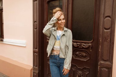 Komik güzel mutlu kadın vintage bir ahşap kapı sokakta yakınındaki şık bir ceket bir gülümseme