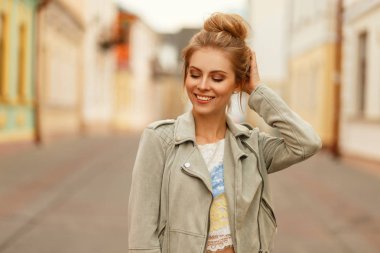 Güzel genç kız modeli şehrin şık bir ceket bir gülümseme