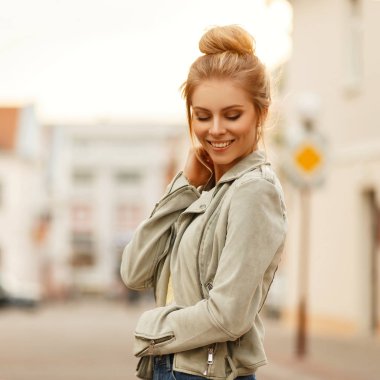 Açık havada şehirde şık bir ceket bir gülümseme mutlu güzel neşeli kadın