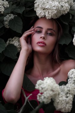 Taze çiçekler ile Bush pembe elbiseli güzel bir moda kadın portresi