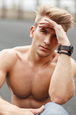 Şık bir saç modeli ile sağlıklı bir vücut sokakta oturan bir güzel sportif model adam portresi