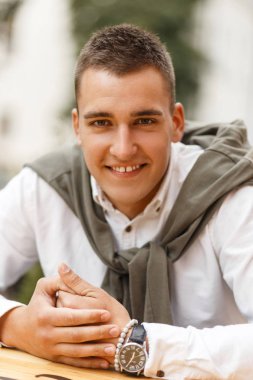 Mutlu başarılı yakışıklı şık giysiler şehrin bir kafede oturmuş