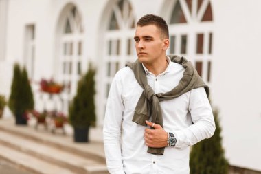 Şık yakışıklı genç bir beyaz gömlekli bir kazak şehir