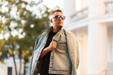 Güneş gözlüğü ve kentin moda kot ceket şık yakışıklı genç model