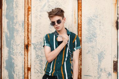 Saç moda yaz giysileri duvar sokak yakınındaki poz gözlüklü adamla şık yakışıklı genç modeli