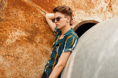 Moda yakışıklı delikanlı yakınındaki bir metal paslı duvar sokak parlak renkli gömlekli gözlüklü