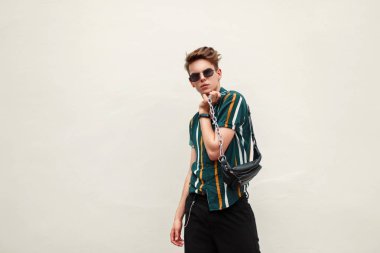 Plaj çantası plaj renkli gömlekli gözlüklü şık genç yakışıklı adam