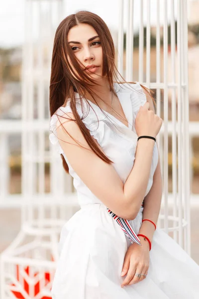 Beyaz Çit Yakınındaki Beyaz Elbiseli Şık Genç Güzel Kadın Modeli — Stok fotoğraf