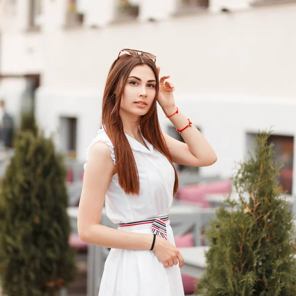 优雅美丽的年轻女子在白色的礼服与太阳镜在城市 — 图库照片