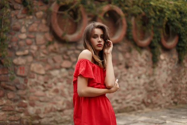 时尚美丽的年轻女子在 Fashiot 红色复古礼服摆在公园与旧石墙与管道 — 图库照片