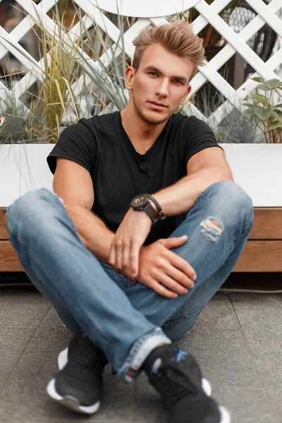 Handsome Young Man Model Hairstyle Black Shirt Jeans Sneakers Sits — Stock Photo, Image