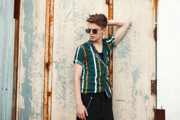 vintage paslı metal duvara yakın poz moda plaj gömlekli gözlüklü yakışıklı genç adam