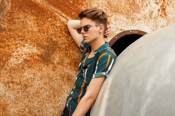 Moda yakışıklı delikanlı yakınındaki bir metal paslı duvar sokak parlak renkli gömlekli gözlüklü