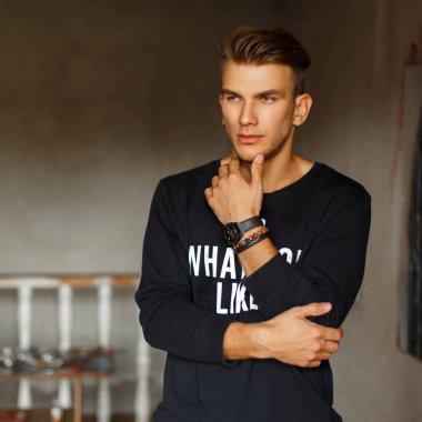 Şık şık yakışıklı bir kazak metin ile sanat stüdyosu duruyor. Sanatçı