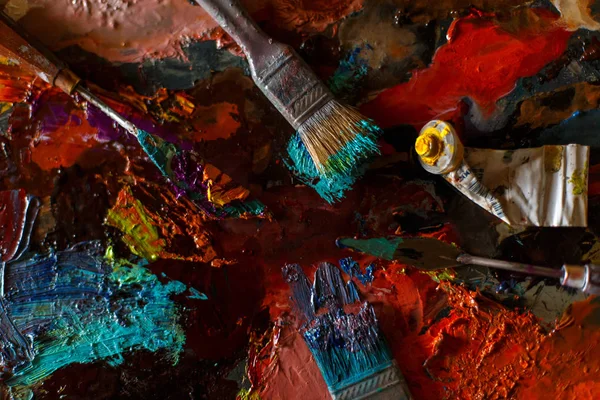 set of artist, brushes and oil paint on a colorful abstract background