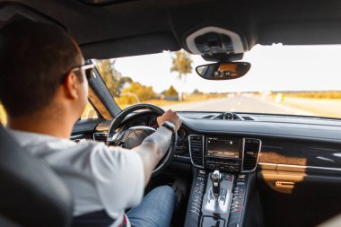 şık genç iş adamı bununla birlikte güneş gözlüklü bir lüks otomobil seyahat