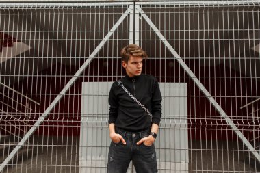 Şık yakışıklı genç adam sokakta siyah casual moda giysileri