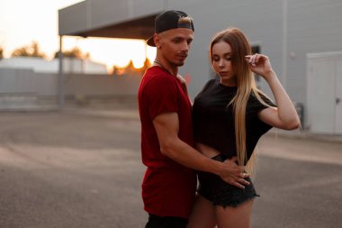 Güzel moda genç çift sokakta günbatımında sarılma