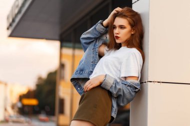 Güzel şık kadın şehrin gri bir T-shirt ve kot vintage ceket