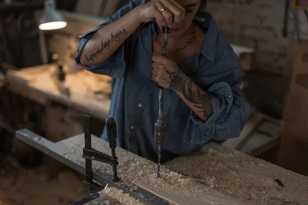 Handmade concept. Female hands work with a wooden product. Girl is working in the workshop