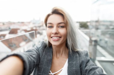 Güzel mutlu genç şık kadın vintage elbise selfie çatıda şehirde yapıyor gülümseme. Seyahat ve fotoğraf çekmek kız
