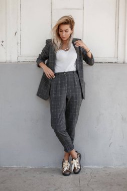Şık katı gri giysiler sokakta duvarın yanında duran kadında moda genç güzel model
