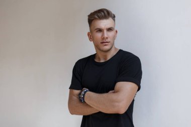 Saç modeli siyah trendy t-shirt beyaz duvarının yakınında şık yakışıklı Amerikalı manken adam