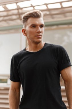 Şık yakışıklı modeli erkek saç modeli şehirde sokakta siyah t-shirt ile