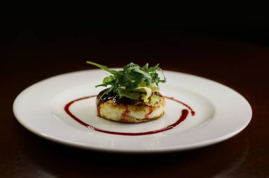 Karanlık bir arka plan üzerinde bir tabakta yeşillikleri ile lezzetli peynirli gözleme