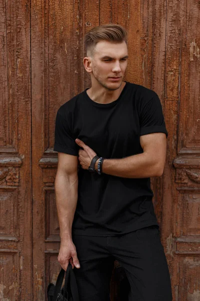 黒のヘアスタイルでおしゃれなハンサムなモデル男性 シャツ ヴィンテージの木製壁そばに立つ — ストック写真
